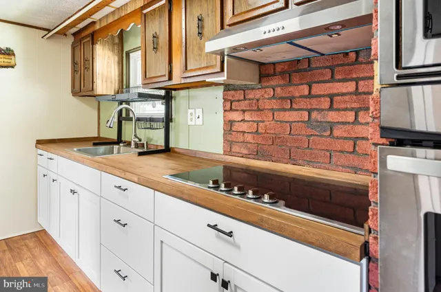 a kitchen with white cabinets and sink