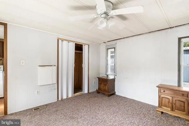 an empty room with fan and entrance