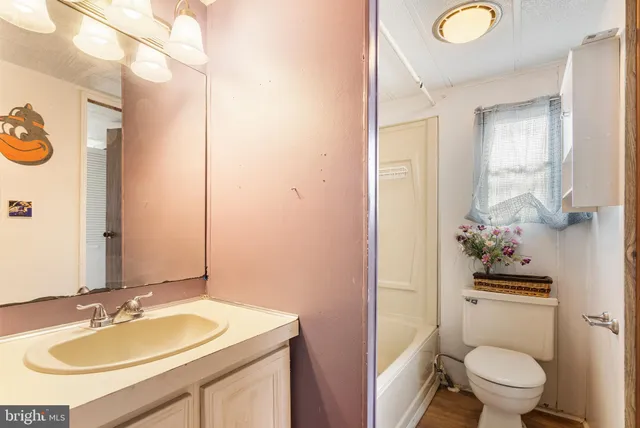 a bathroom with a granite countertop toilet sink and mirror