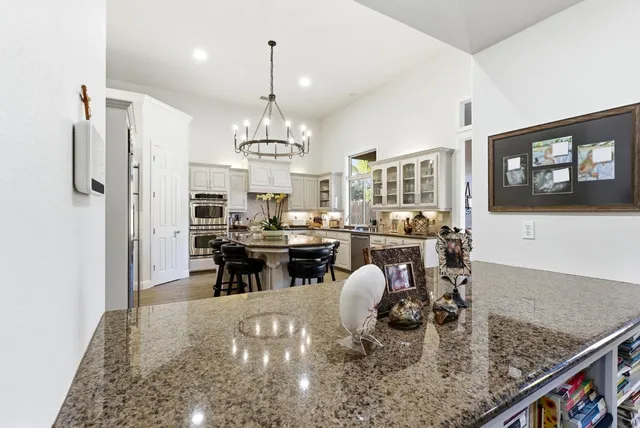 a kitchen with granite countertop white cabinets and stainless steel appliances