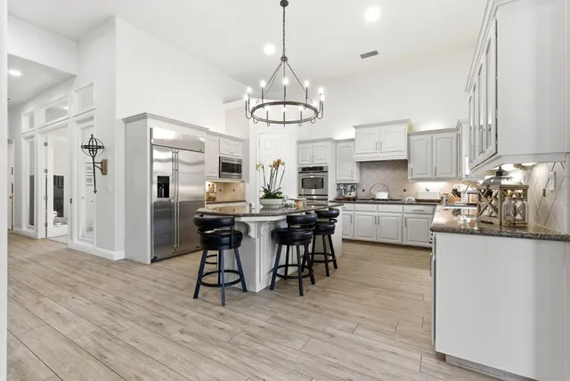 a kitchen with stainless steel appliances granite countertop wooden cabinets a stove and a sink