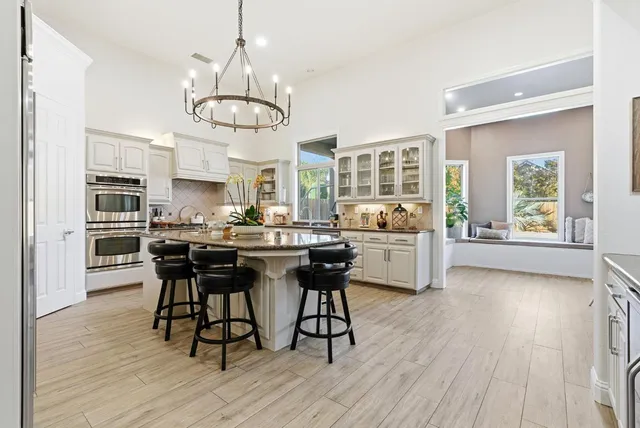 a kitchen with granite countertop stainless steel appliances a sink cabinets and wooden floor
