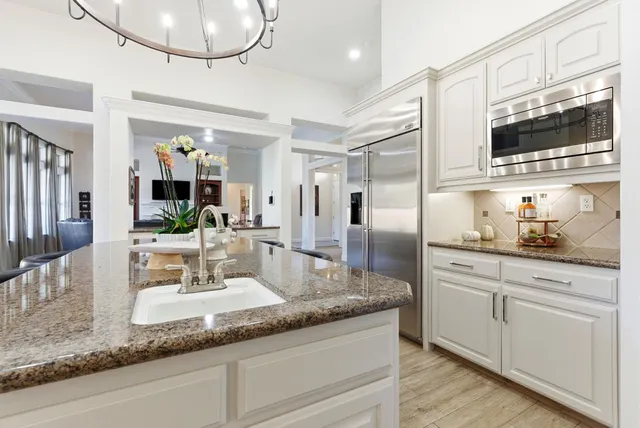 a view of a dining room with furniture a chandelier and wooden floor