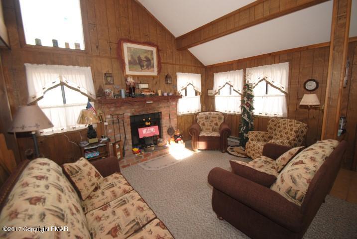 214 Elk Run Road Pocono Lake, PA 18347 - Photo 3 of 26 a living room with furniture large window and fireplace