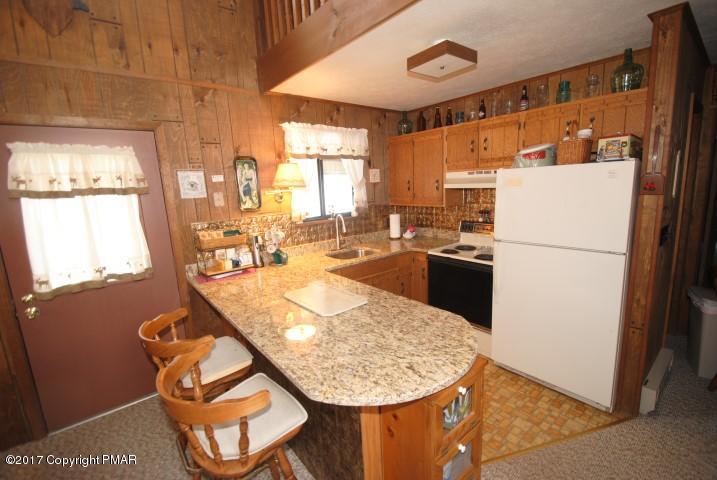 214 Elk Run Road Pocono Lake, PA 18347 - Photo 8 of 26 a kitchen with stainless steel appliances granite countertop a refrigerator a sink a stove and white cabinets
