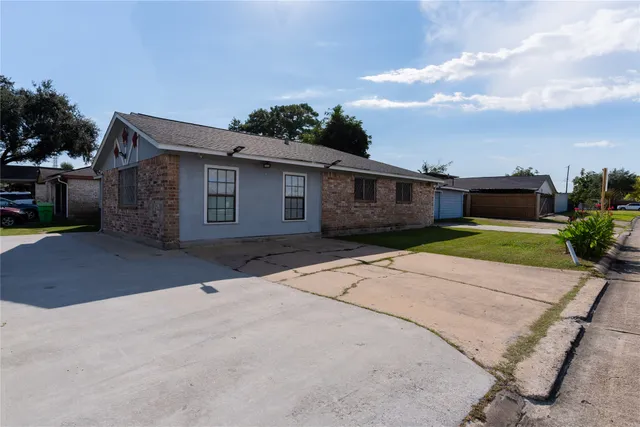 a front view of a house with a yard and potted plants