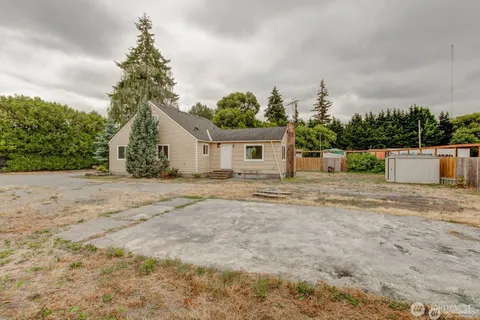 a view of a house with backyard and a tree
