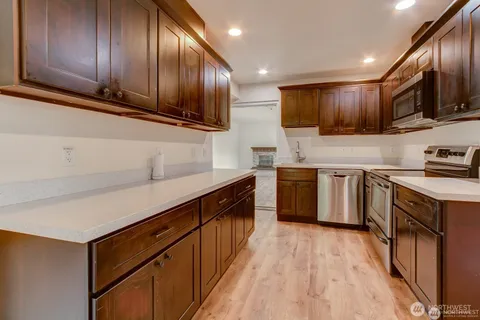 a kitchen with stainless steel appliances granite countertop wooden cabinets a stove top oven a sink and dishwasher