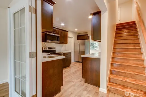a kitchen with stainless steel appliances kitchen island granite countertop a refrigerator and a stove