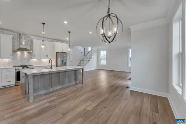 a kitchen with a sink chandelier and wooden floor