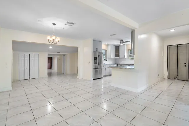 a view of a kitchen with a sink and an empty room