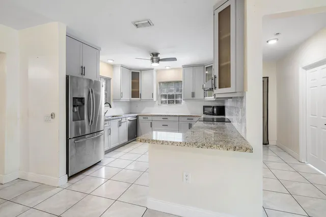 a kitchen with stainless steel appliances granite countertop a refrigerator and a stove top oven
