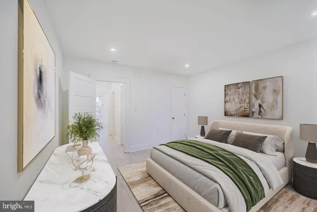 a bedroom with a large bed and a potted plant