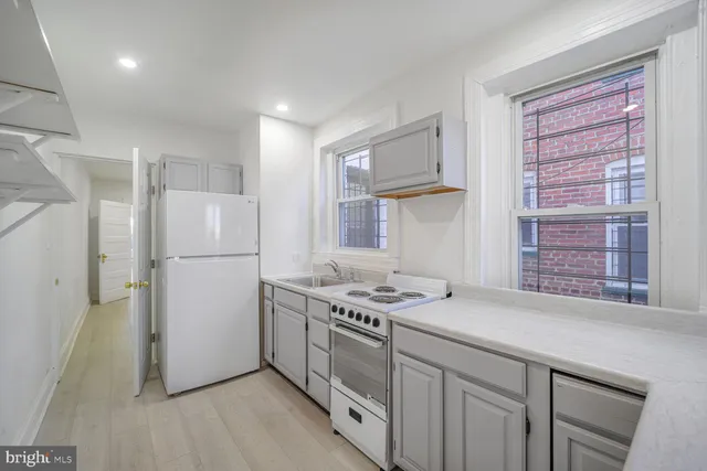 a kitchen with a refrigerator a stove a sink and a window