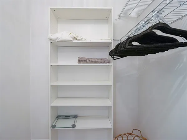 a view of walk in closet with clothes and shoes