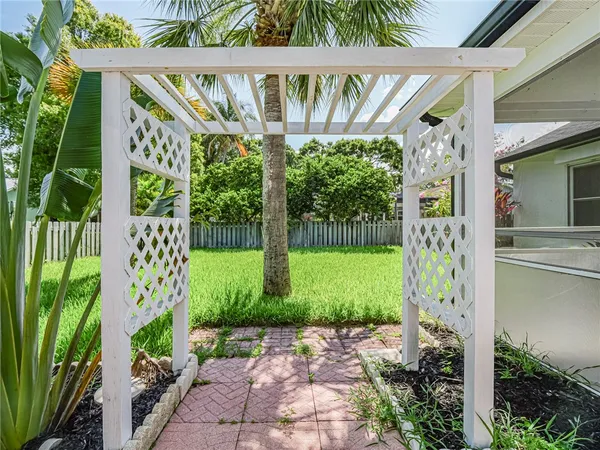 a front view of a house with a big yard and potted plants