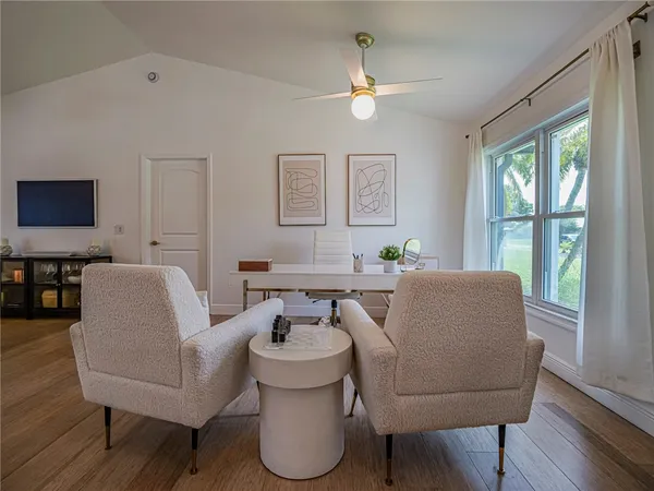 a living room with furniture a flat screen tv and a window