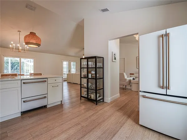 a kitchen with white cabinets and wooden floor