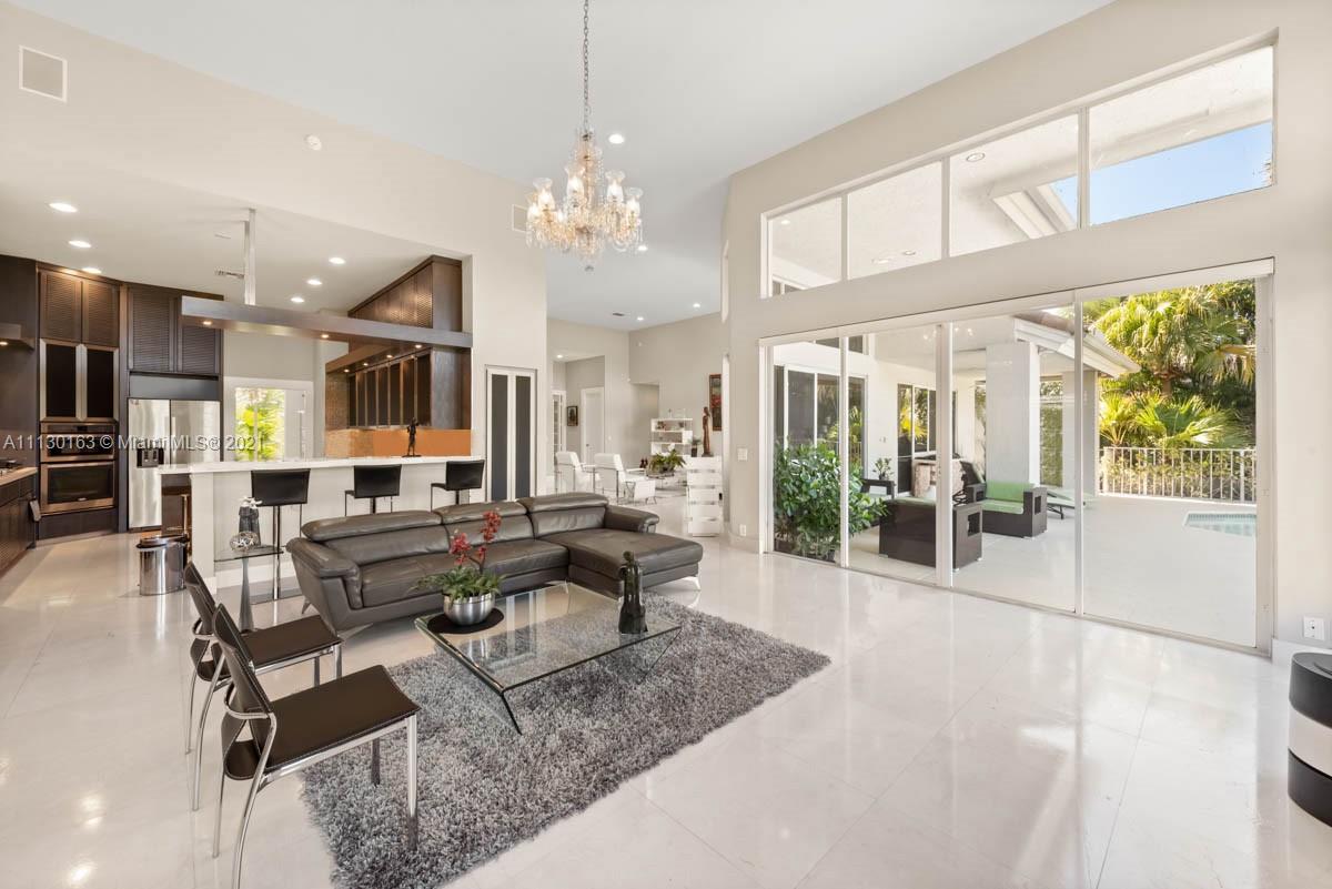 10454 Stonebridge Boulevard Boca Raton, FL 33498 - Photo 7 of 37 a living room with lots of furniture and a chandelier