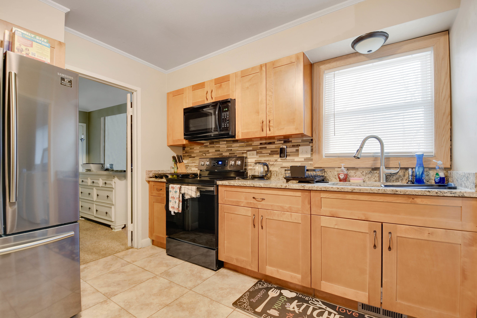 314 Windsor Street Park Forest, IL 60466 - Photo 11 of 20 a kitchen with stainless steel appliances granite countertop a stove a sink and a refrigerator