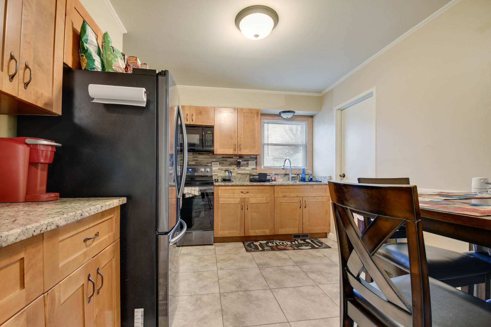 314 Windsor Street Park Forest, IL 60466 - Photo 8 of 20 a kitchen with a table chairs and a refrigerator