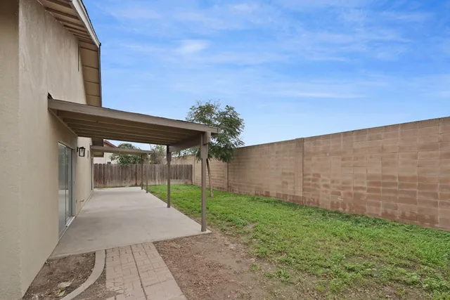 a white house that has tree in front of it