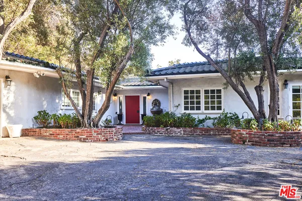 a front view of a house with a yard and potted plants