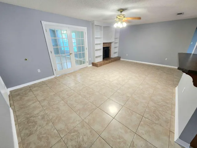 a view of an empty room with window and fireplace