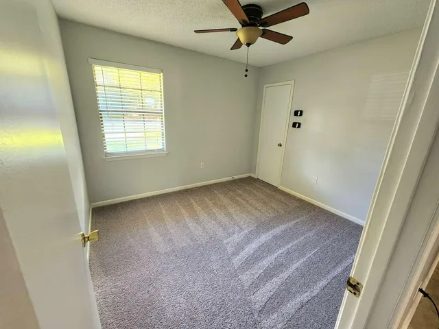 a view of empty room with ceiling fan