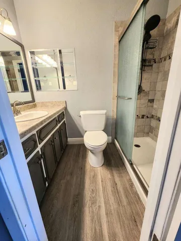 a bathroom with a sink a toilet a mirror and shower