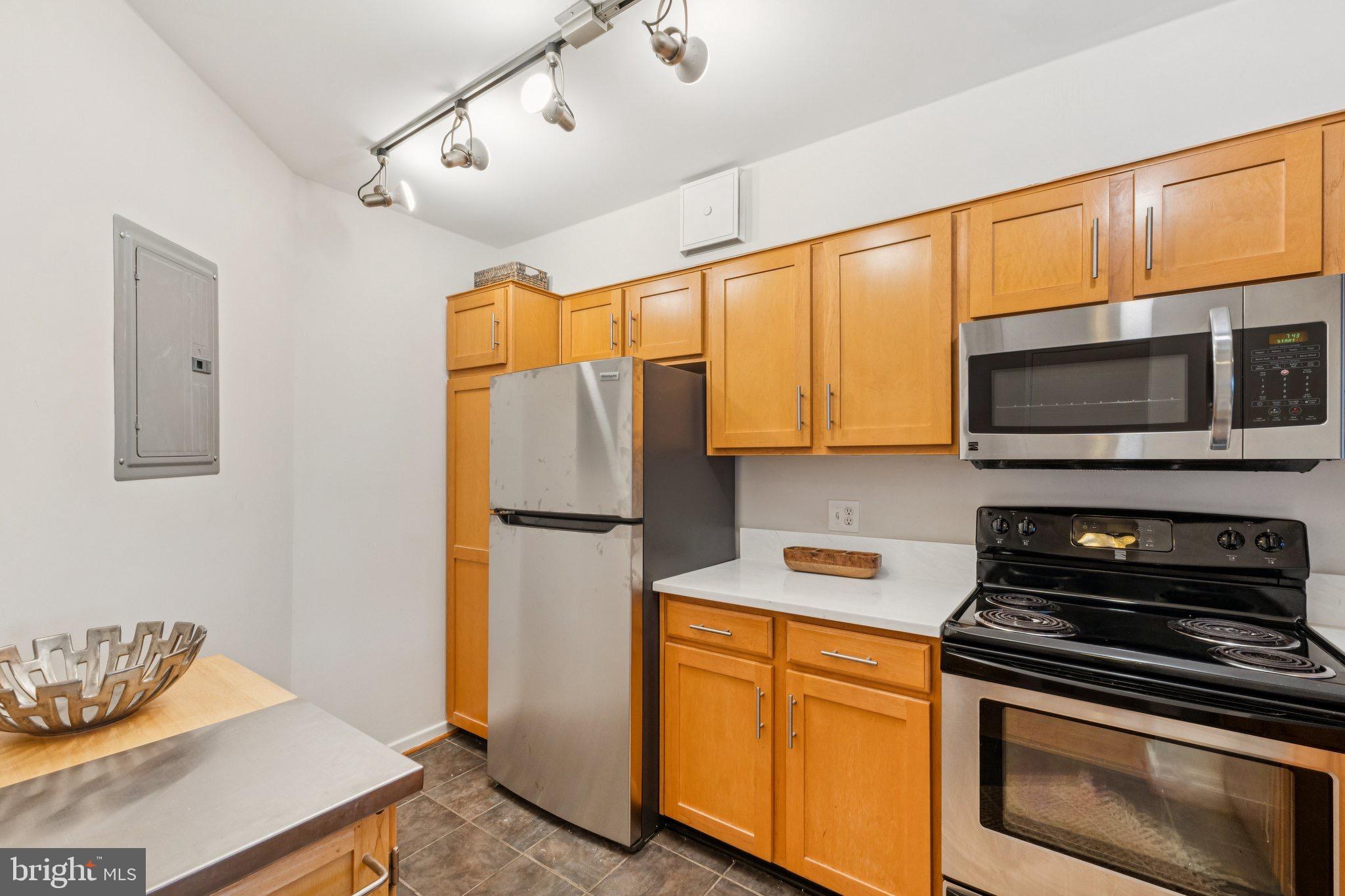 2320 Wisconsin Avenue Northwest, Unit 105 Washington, DC 20007 - Photo 5 of 24 a kitchen with stainless steel appliances a stove a microwave and wood cabinets