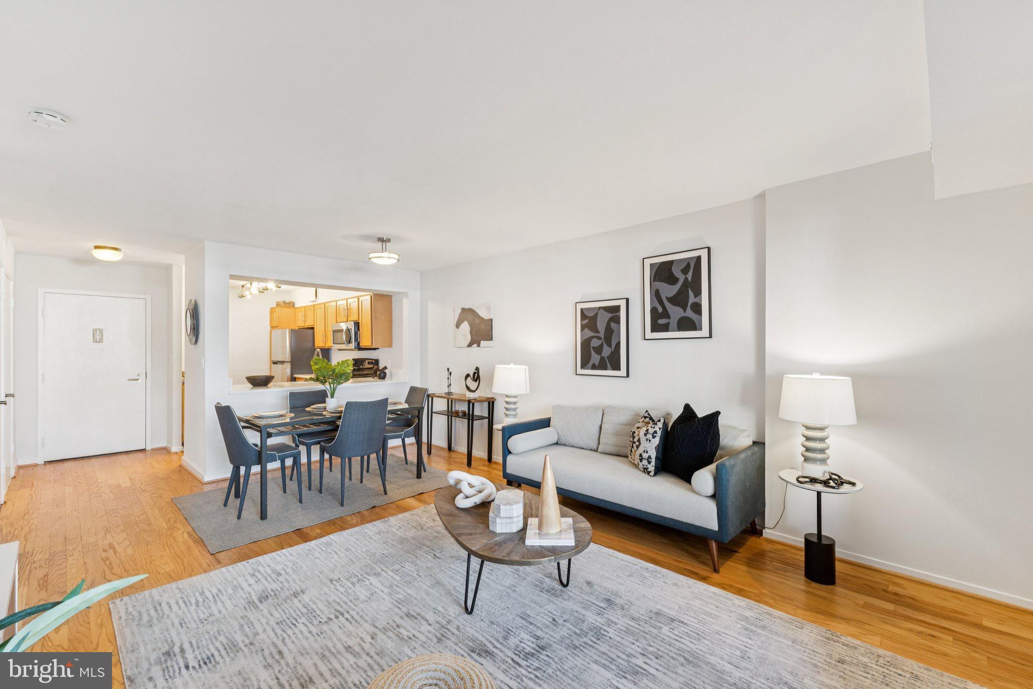 2320 Wisconsin Avenue Northwest, Unit 105 Washington, DC 20007 - Photo 9 of 24 a living room with furniture and a dining table with wooden floor