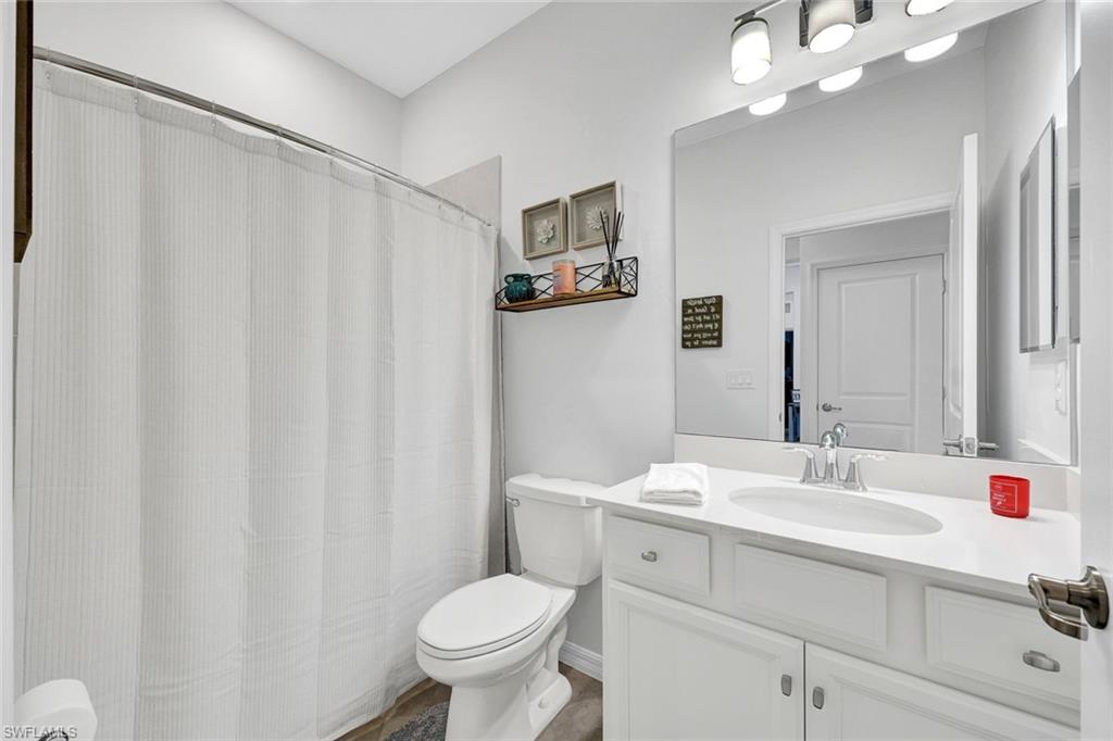 2622 Scarlet Way Naples, FL 34120 - Photo 14 of 24 a bathroom with a sink a toilet and a mirror