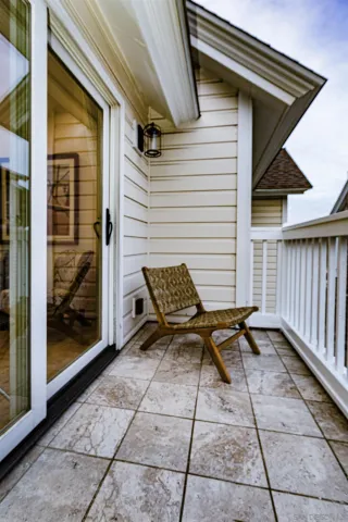 a view of a patio with table and chairs and floor to ceiling window