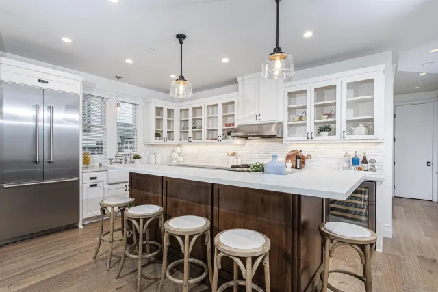 a kitchen with stainless steel appliances kitchen island granite countertop a dining table chairs and sink