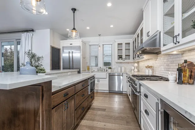 a kitchen with stainless steel appliances granite countertop a sink a stove and a refrigerator