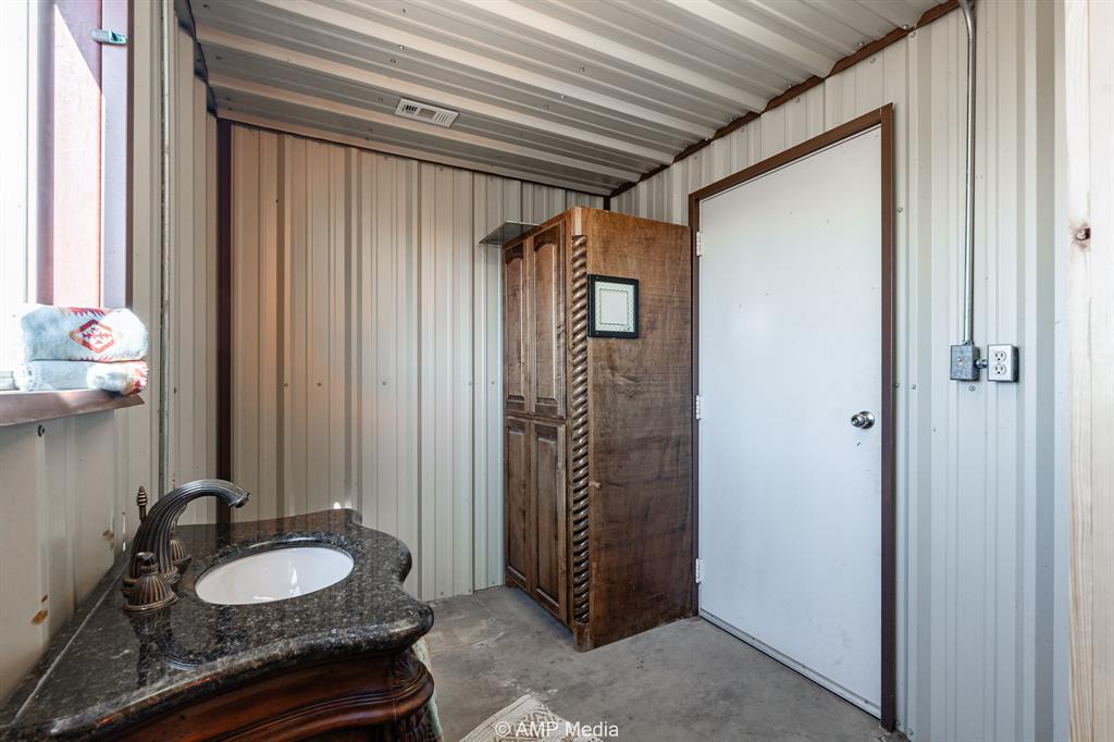 Cr Cr 450th Roscoe, TX 79545 - Photo 20 of 39 a bathroom with a granite countertop sink and a mirror