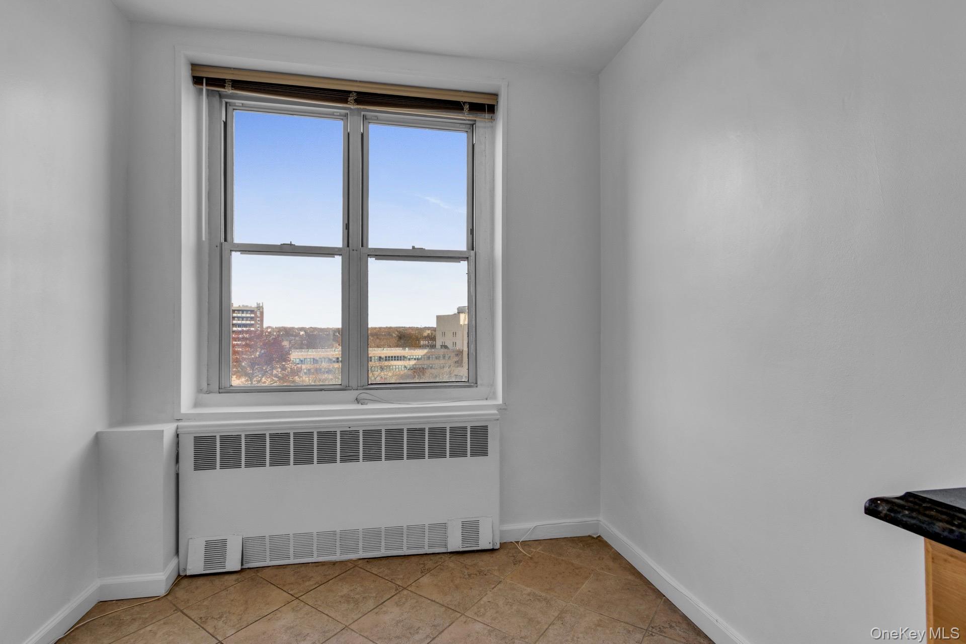 211-40 18th Avenue, Unit 6C Queens, NY 11360 - Photo 13 of 41 Spare room featuring radiator and baseboards