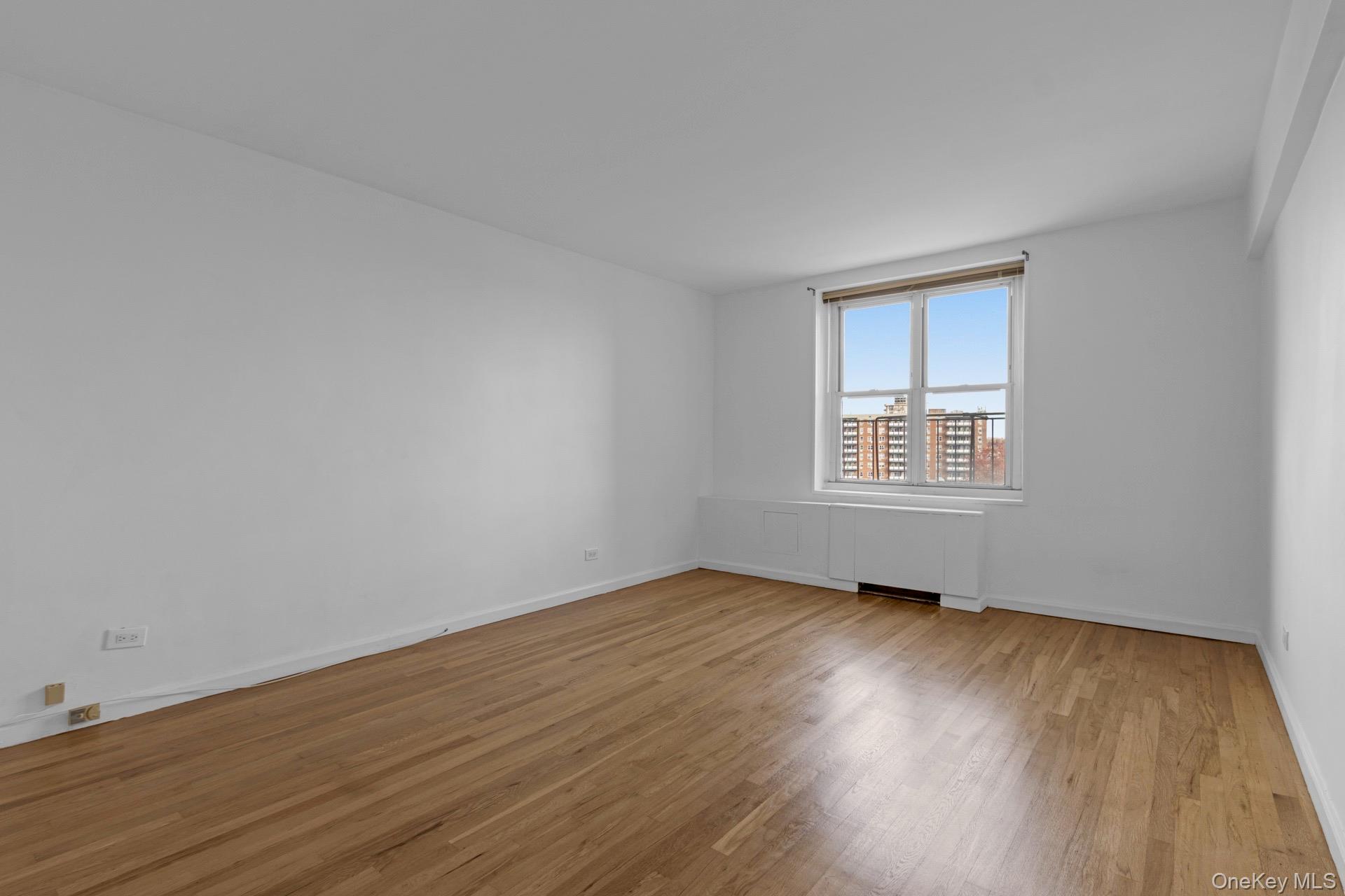 211-40 18th Avenue, Unit 6C Queens, NY 11360 - Photo 18 of 41 Unfurnished room featuring light wood finished floors and baseboards