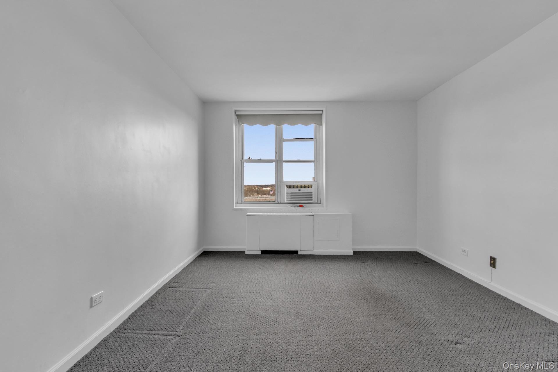 211-40 18th Avenue, Unit 6C Queens, NY 11360 - Photo 22 of 41 Spare room featuring carpet floors and baseboards