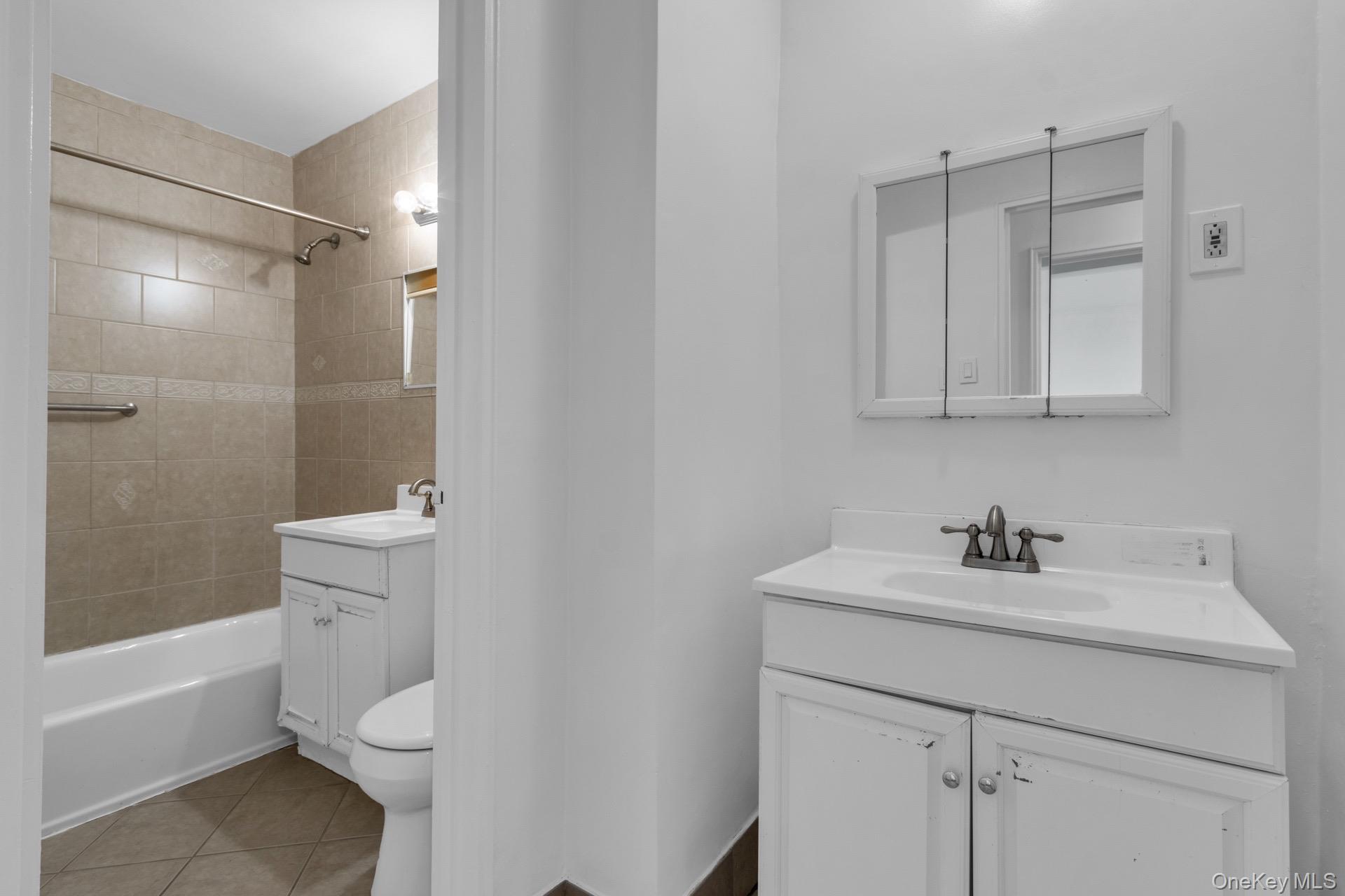 211-40 18th Avenue, Unit 6C Queens, NY 11360 - Photo 32 of 41 Full bath featuring two vanities, bathtub / shower combination, and light tile patterned flooring