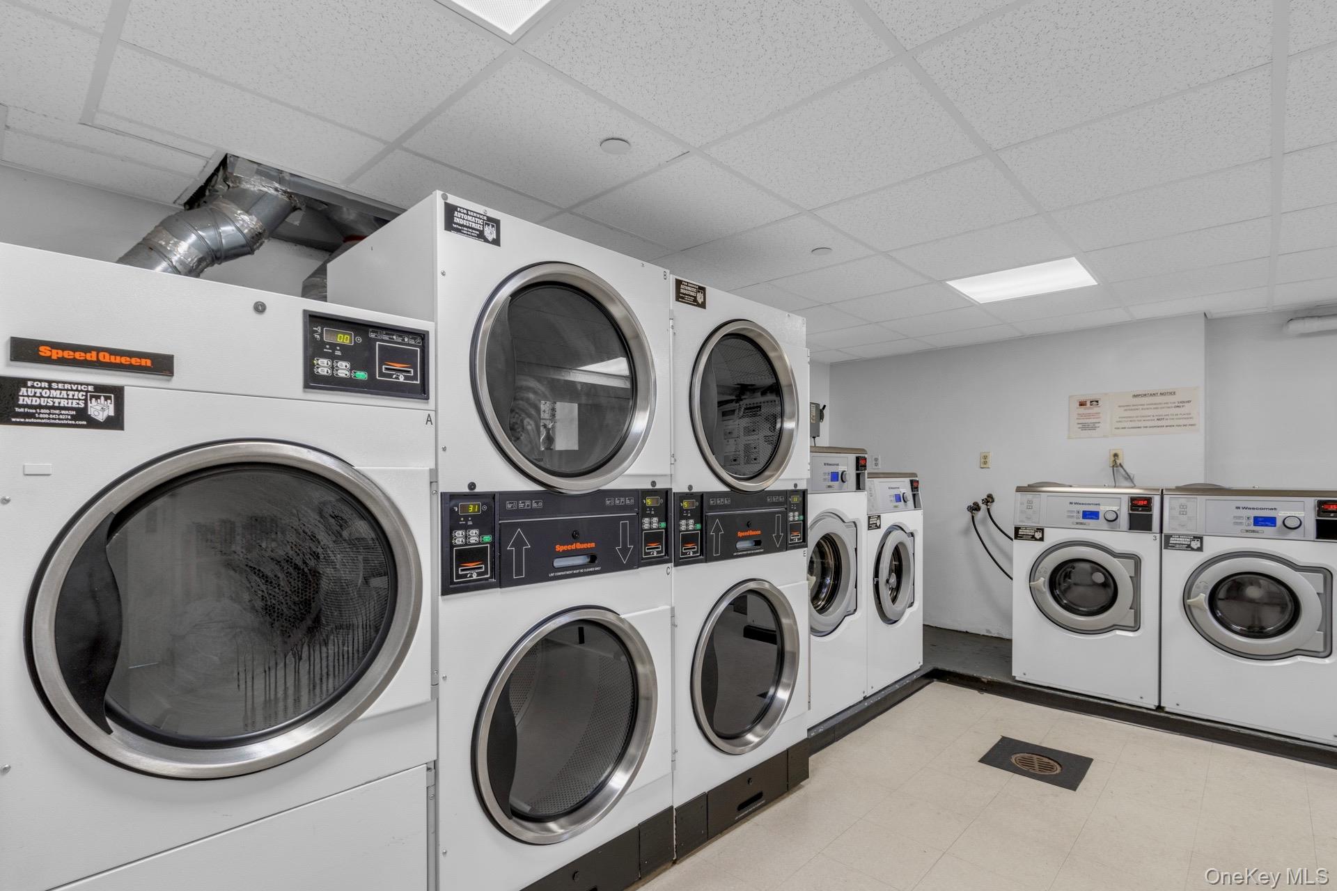 211-40 18th Avenue, Unit 6C Queens, NY 11360 - Photo 35 of 41 Shared laundry room with a drop ceiling, washing machine and clothes dryer, and stacked washing machine and dryer