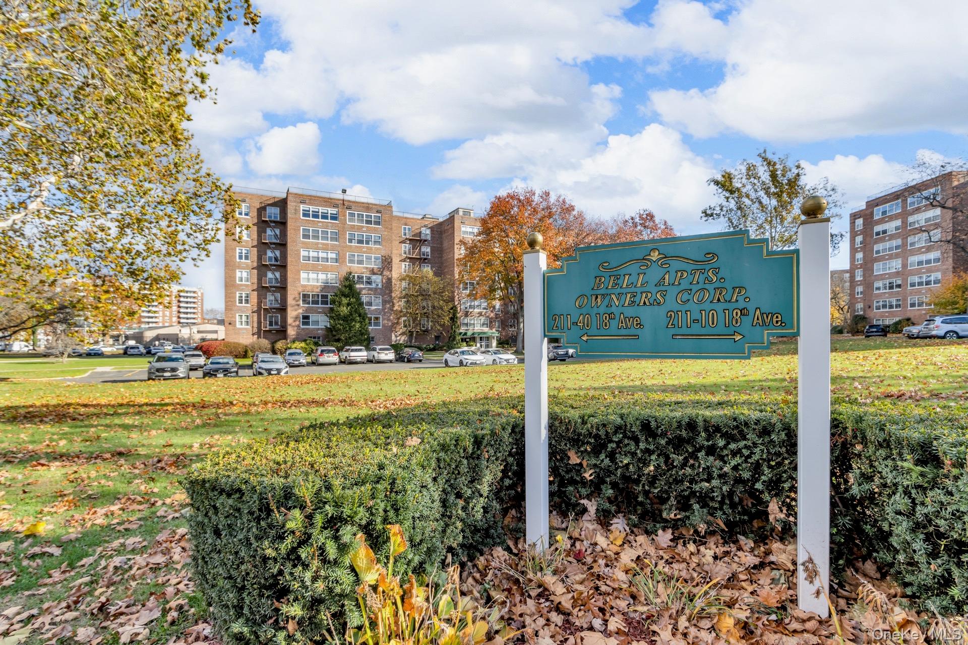 211-40 18th Avenue, Unit 6C Queens, NY 11360 - Photo 36 of 41 Community sign featuring a lawn