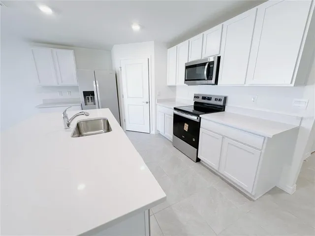 a kitchen with white cabinets and stainless steel appliances