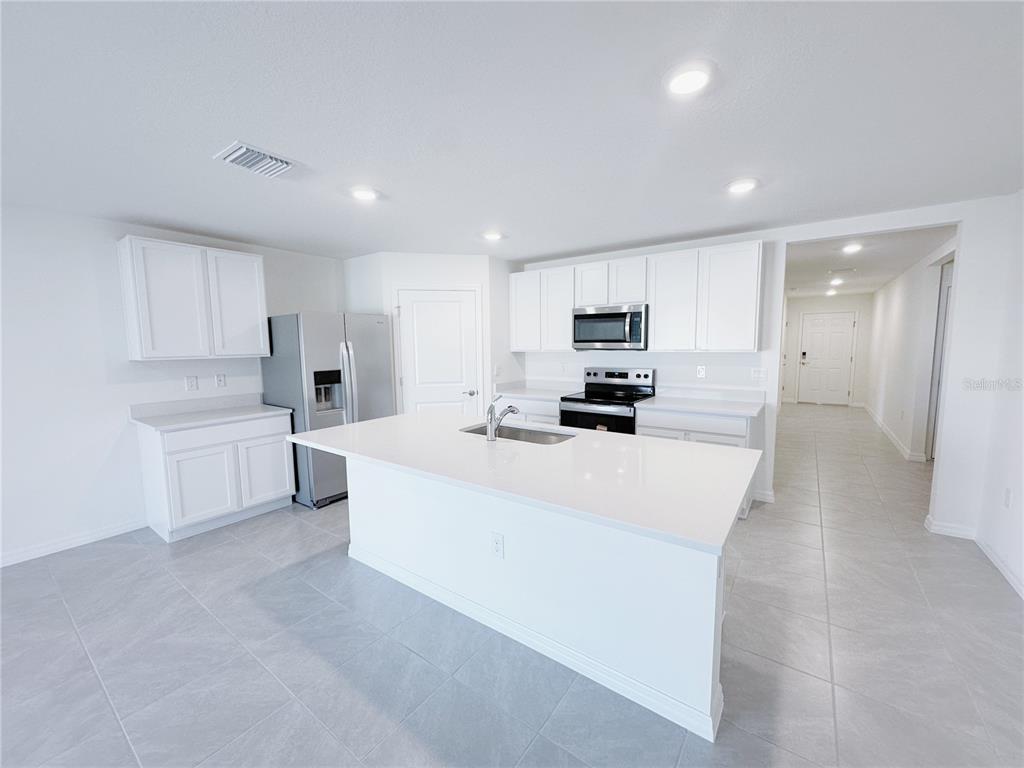 4683 Southwest 88th Lane Ocala, FL 34476 - Photo 4 of 16 a large white kitchen with a white stove top oven and white cabinets