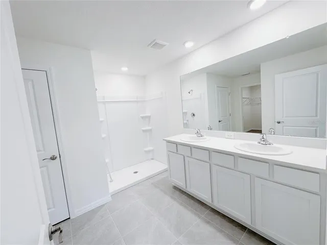a bathroom with a double vanity sink and mirror