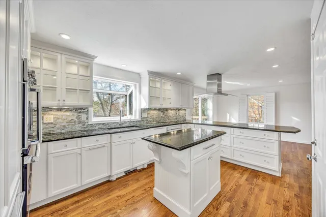 a kitchen with granite countertop white cabinets and white appliances