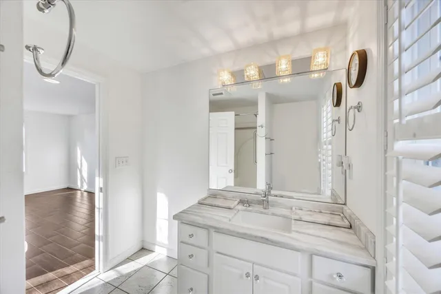 a bathroom with a granite countertop sink and a mirror