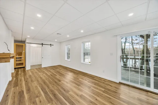 a view of empty room with wooden floor and fireplace