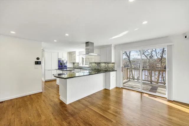 a kitchen with stainless steel appliances granite countertop a stove top oven a sink and a granite counter tops with white walls